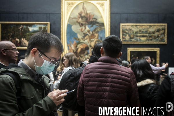 Les visiteurs du musée du Louvre se protègent du Covid-19.