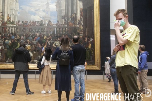 Les visiteurs du musée du Louvre se protègent du Covid-19.