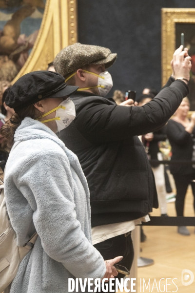 Les visiteurs du musée du Louvre se protègent du Covid-19.