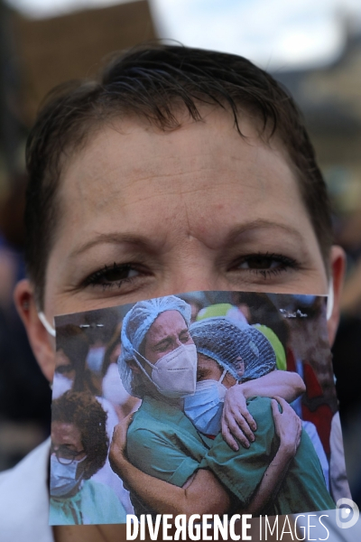 Personnel soignant portant un masque protecteur avec les slogans. Health workers wearing a protective face mask with the slogans.