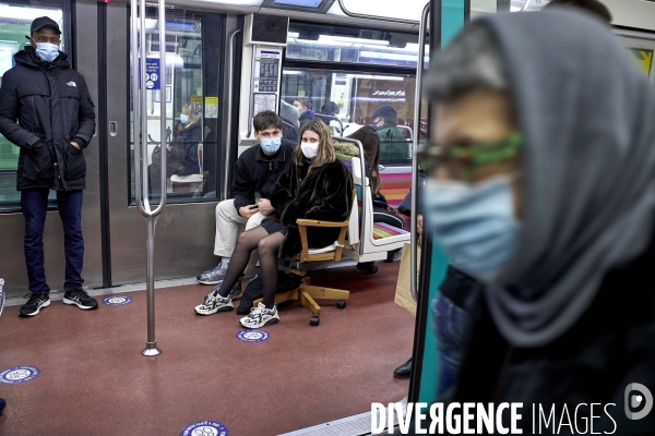 Metro, deux jeunes gens avec masques et un fauteuil