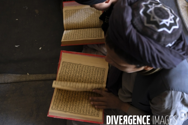 Des garçons et des filles afghans llire le Coran, le livre sacré de l islam, à la madrasa de Kandahar. Afghan boys and girls read Quran, Islam s holy book, at madrasa in Kandahar.