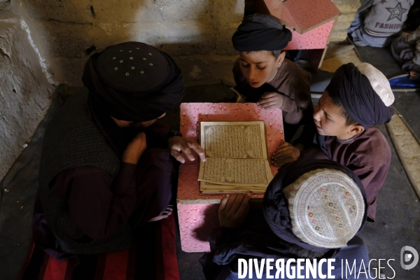 Des garçons et des filles afghans llire le Coran, le livre sacré de l islam, à la madrasa de Kandahar. Afghan boys and girls read Quran, Islam s holy book, at madrasa in Kandahar.