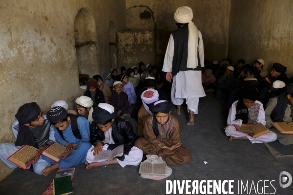 Des garçons et des filles afghans llire le Coran, le livre sacré de l islam, à la madrasa de Kandahar. Afghan boys and girls read Quran, Islam s holy book, at madrasa in Kandahar.