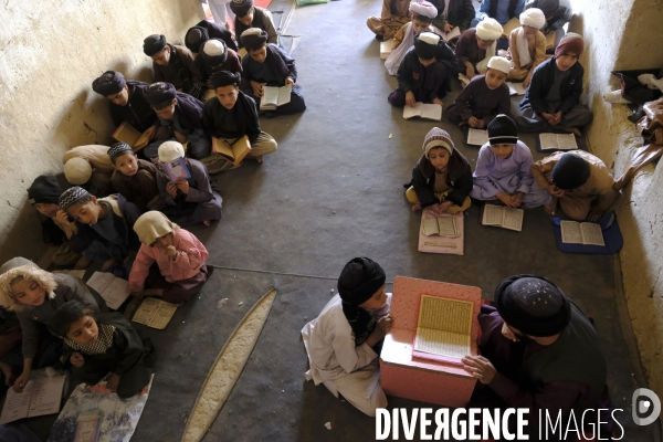 Des garçons et des filles afghans llire le Coran, le livre sacré de l islam, à la madrasa de Kandahar. Afghan boys and girls read Quran, Islam s holy book, at madrasa in Kandahar.