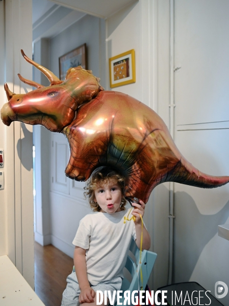 Un petit Garçon joue chez lui avec son ballon dinosaure