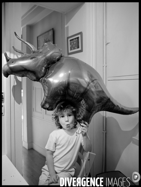 Un petit Garçon joue chez lui avec son ballon dinosaure