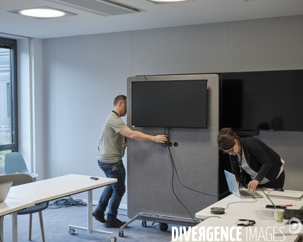 CPAM de Vannes. Installation d’un ecran pour une visioconference.