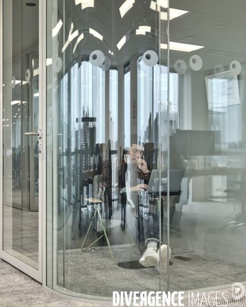 Siege social de l’entreprise Bic à Clichy, un employe en Visio conference dans un espace reduit,  vitre et insonorise 