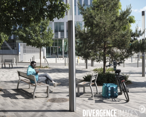 Nanterre. Livreur Deliveroo sur un des banc du mobilier urbain 