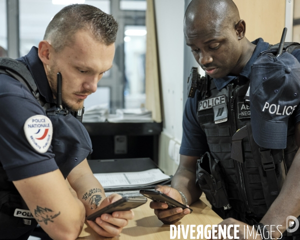Policiers consultant le nouveau terminal mobile NEO.