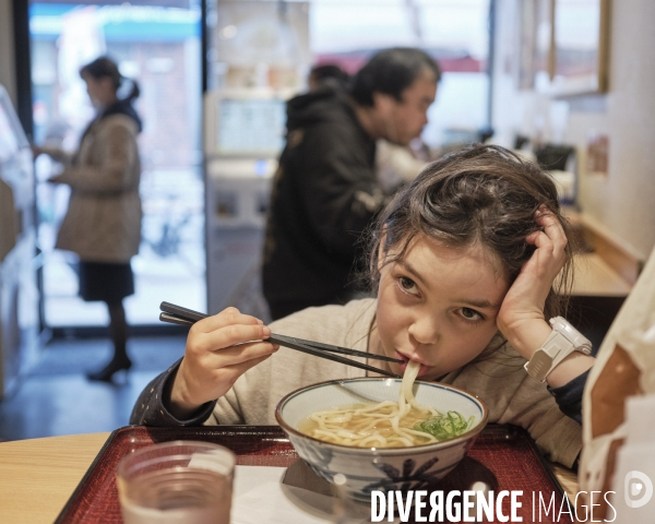 Enfant mangeant une soupe de nouilles japonaises ( udon) 