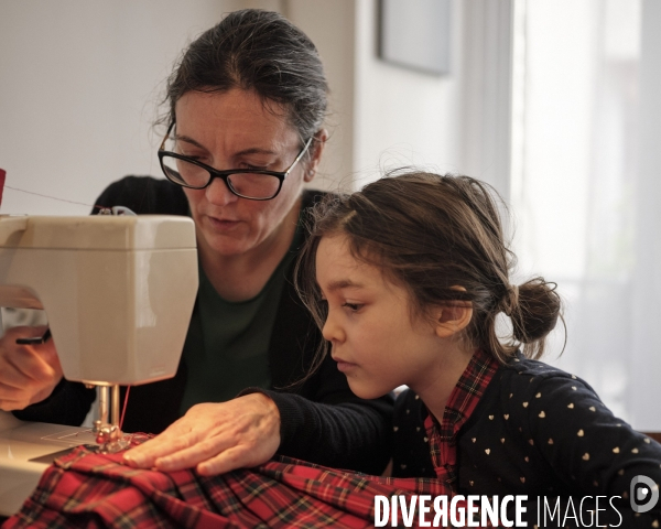Enfant cousant avec sa mère une jupe écossaise