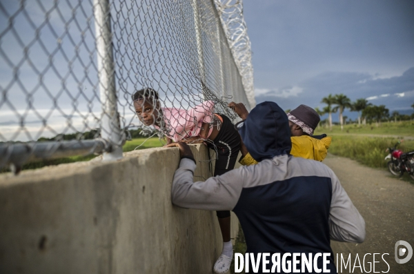 Frontiere entre haiti et la republique dominicaine, separee par un mur.