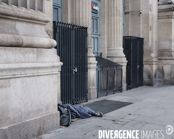 JO, 2024, un sans abri couché devant les grilles de  la façade de la gare du Nord