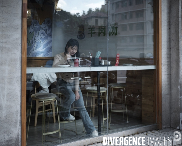 Shanghaï, jeune femme attablé dans un café du centre ville