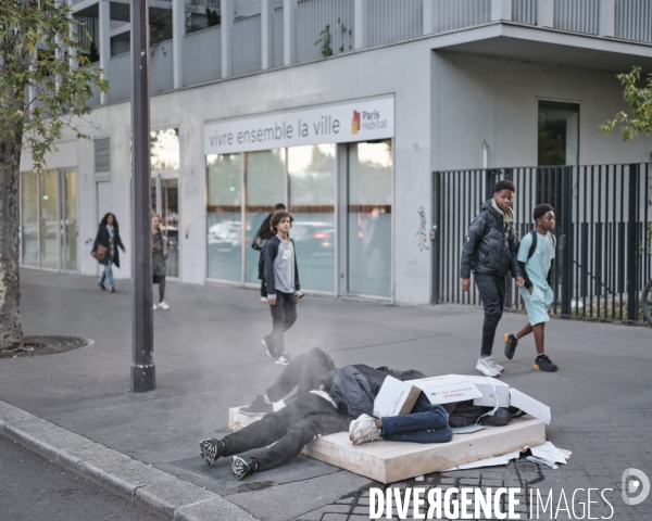 Des hommes endormis sur un matelas devantl Paris Habitat
