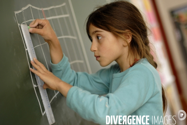 Ecole primaire : enfant en classe CE1 à CE2. School pupil in class