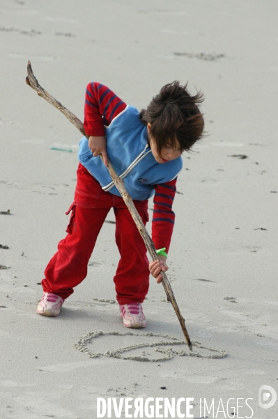 Enfance : enfants et bébés à la plage, au bord de la mer en hors saison estivale. Childhood : holidays at the beach.