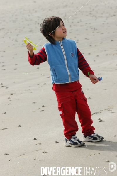 Enfance : enfants et bébés à la plage, au bord de la mer en hors saison estivale. Childhood : holidays at the beach.