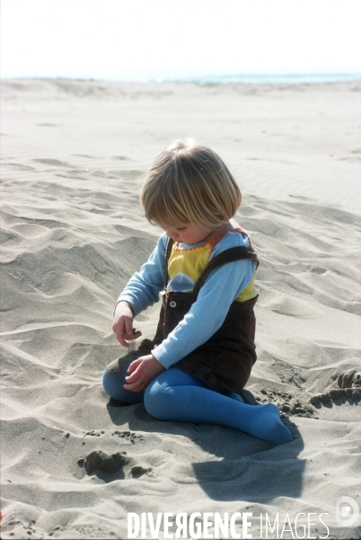 Enfance : enfants et bébés à la plage, au bord de la mer en hors saison estivale. Childhood : holidays at the beach.