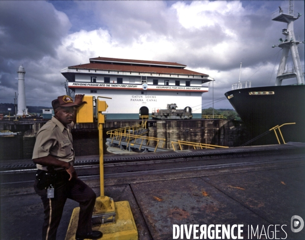 Gardien armé sur les bords du Canal de Panama devant les ecluses : cargo passant une ecluse