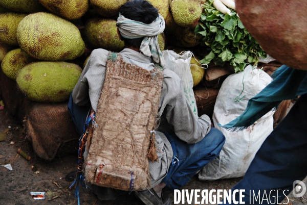 Delhi, les Halles de Sabji Mandi. Dans un tumulte vital, existent ensemble maîtres et serviteurs, paysans, porteurs, commerçants et négociants, et s échangent les marchandises (legumes et fruits) qui nourriront la Ville dans la journée