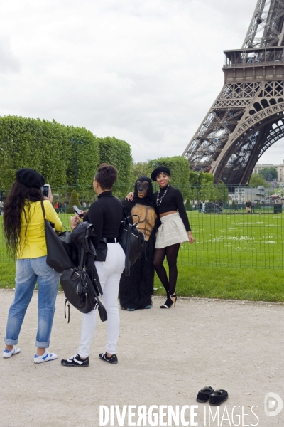 Touristes a Paris.Autour de la tour  Eiffel.Deguisee en gorille, elle se fait prendre en photo avec ces touristes americaines