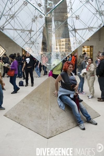 Touristes a la pyramide inversee au Louvre..Seance photo; gestes et poses quasi rituel sous la pointe de la pyramide inversée