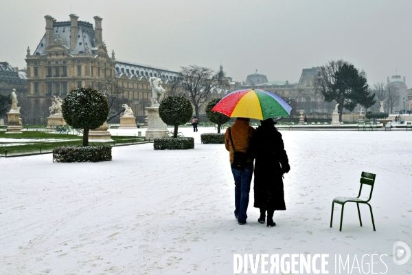 La nature dans la ville Série 02.Aux tuileries,,un couple abrité sous un  parapluie multicolore se promene sous la neige