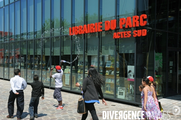 Photo du mois-Juillet 2013.Chaud devant ! Canicule au parc de la Villette,un enfant arrose ses copains avec une bouteille d eau.
