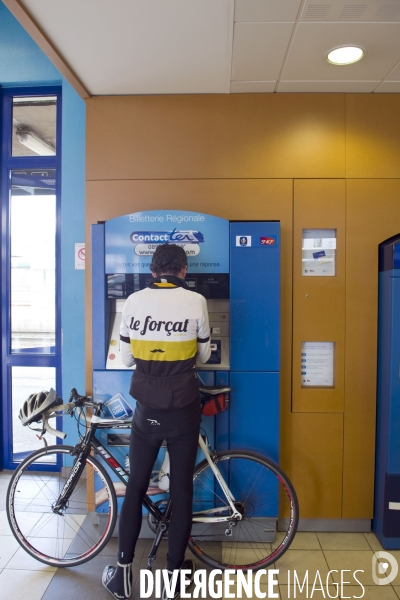 Economie - illustration.Cycliste en tenue Le Forcat devant un distributeur automatique de billets regionaux de la gare d Hazebrouck.