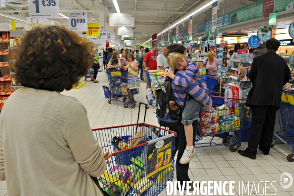 Commerce illustration.Une enfant dort dans les bras de sa mére dans la file d attente aux caisses