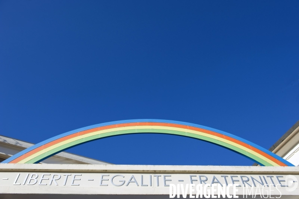 Illustration Novembre 2013.Au dessus de la porte d entree d une ecole,un arc en ciel  et la devise de la republique française: Liberte-Egalite-Fraternite