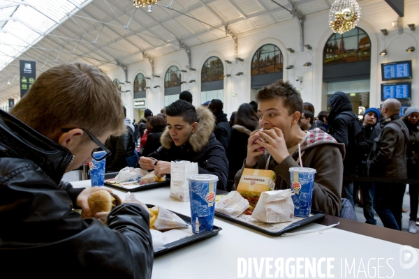 Des jeunes dejeunent au Burger King  dans la galerie marchande de la Gare Saint Lazare