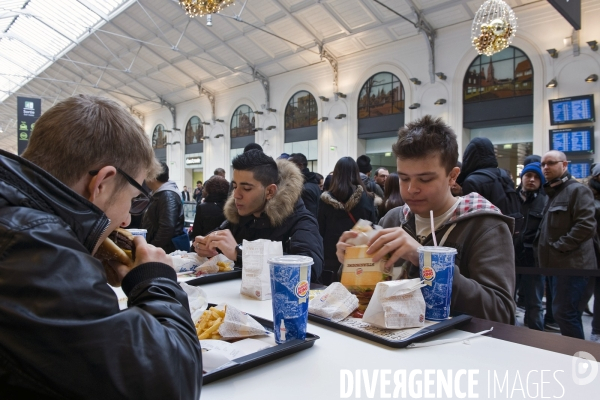 Des jeunes dejeunent au Burger King  dans la galerie marchande de la Gare Saint Lazare