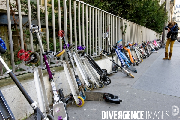 Illustration Mars 2014.Des patinettes et trotinettes attachees a une grille devant le groupe scolaire  Fenelon Sainte Marie.