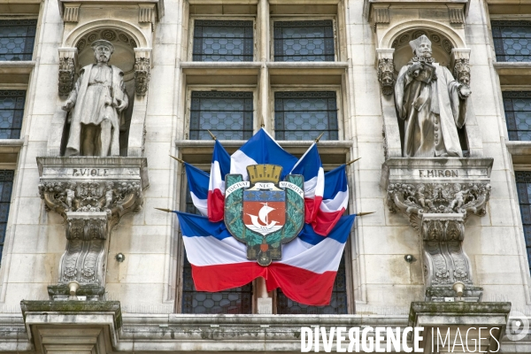 Illustration Mai 2014.La façade de la mairie de Paris pavoisée avec des drapeaux français.Armoiries de Paris et sa devise en latin Fluctuat nec Mergitur