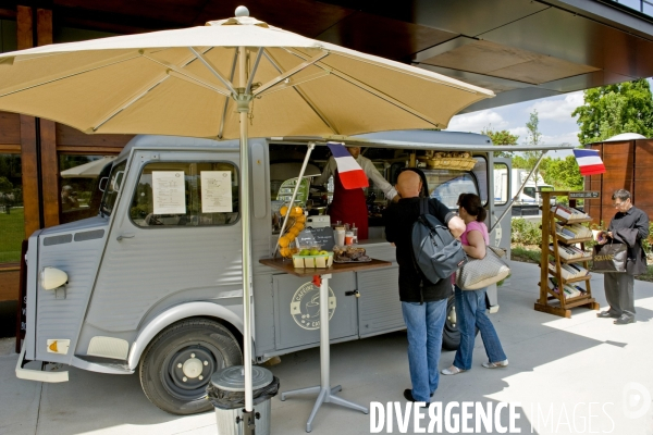 Un food truck, propose a bord d une camionnette Citroen Type H, une restauration rapide sur place ou a emporter et des livresa emprunter en libre service