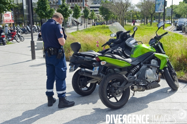 Illustration Juin 2014.Un policier verbalise des motos stationnees sur le trottoir