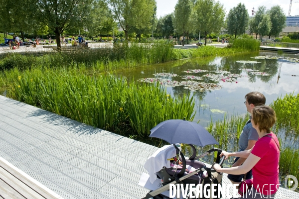 Illustration Juin 2014.Un jeune couple promene son bebe en poussette au  parc Martin Luther King dans la zac Clichy Batignolles.