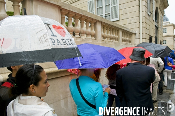 Illustration Juillet 2014.Touristes sous la pluie,équipes d un parapluie avec l inscription I love Paris,dans une file d attente pour visiter le musee d Orsay.