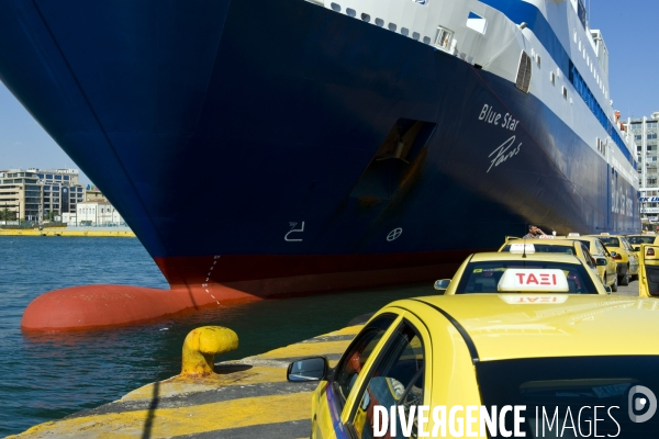 Grece. Ete 2014.Sur un des quais du port du Piree , une file de taxis jaunes le long d un ferry de la compagnie Blue Star Ferry.