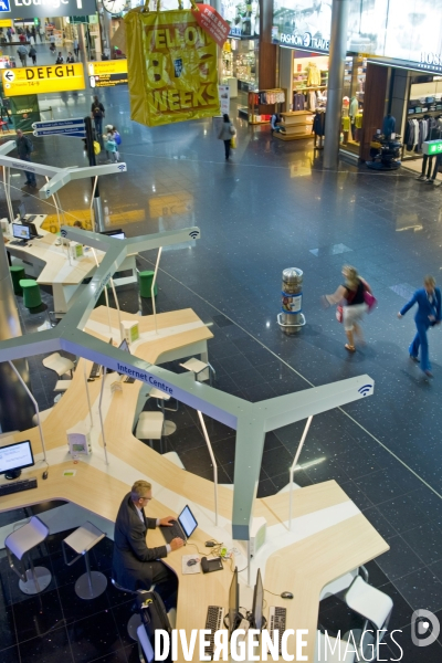 Aeroport de Schipol Amsterdam.Un homme d affaires travaille sur con ordinateur portable au centre internet d un satellite d embarquement.