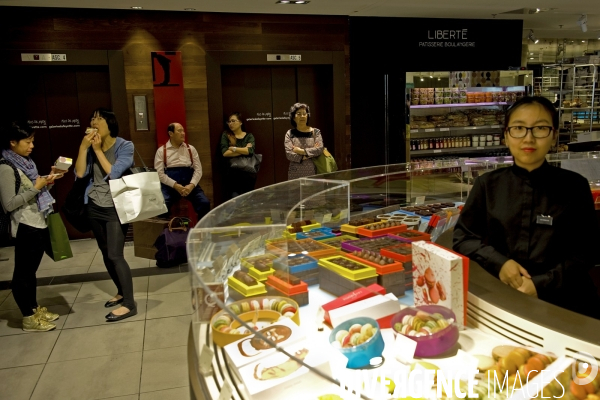 Illustration Septembre 2014. Touristes japonais degustant les patisseries Pierre Herme au grand magasin Galeries Lafayette Gourmet.