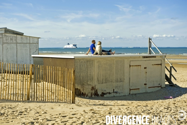 Illustration Octobre 2014.n couple prend le soleil assis sur le toit d un chalet de plage a Calais