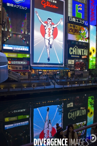 Osaka. Dans le quartier de Minami, l artere de Dotonbori concentre restaurants ,boutiques dans une debauche d enseignes lumineuses.Sur le canal, l animation, a heure fixe, du confiseur Glico