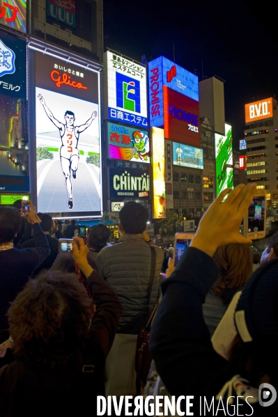 Osaka. Dans le quartier de Minami, l artere de Dotonbori concentre restaurants ,boutiques dans une debauche d enseignes lumineuses.Sur le canal, l animation, a heure fixe, du confiseur Glico