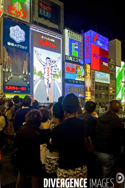 Osaka. Dans le quartier de Minami, l artere de Dotonbori concentre restaurants ,boutiques dans une debauche d enseignes lumineuses.Sur le canal, l animation, a heure fixe, du confiseur Glico