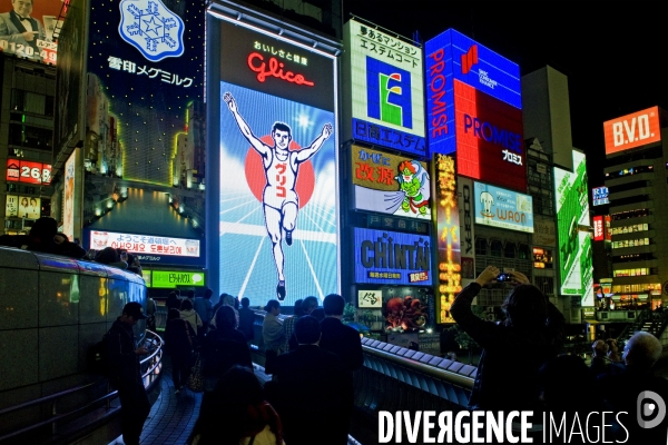 Osaka. Dans le quartier de Minami, l artere de Dotonbori concentre restaurants ,boutiques dans une debauche d enseignes lumineuses.Sur le canal, l animation, a heure fixe, du confiseur Glico